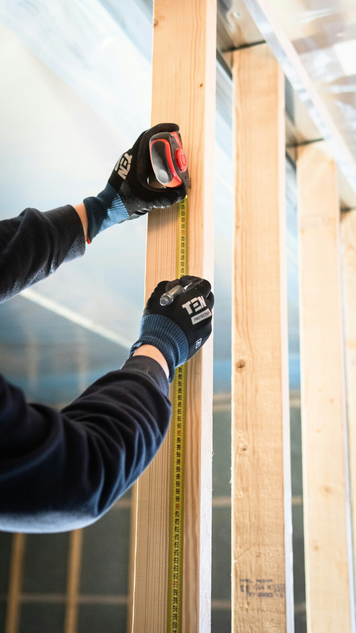 Worker in protective gloves sanding trim during an interior finish stage