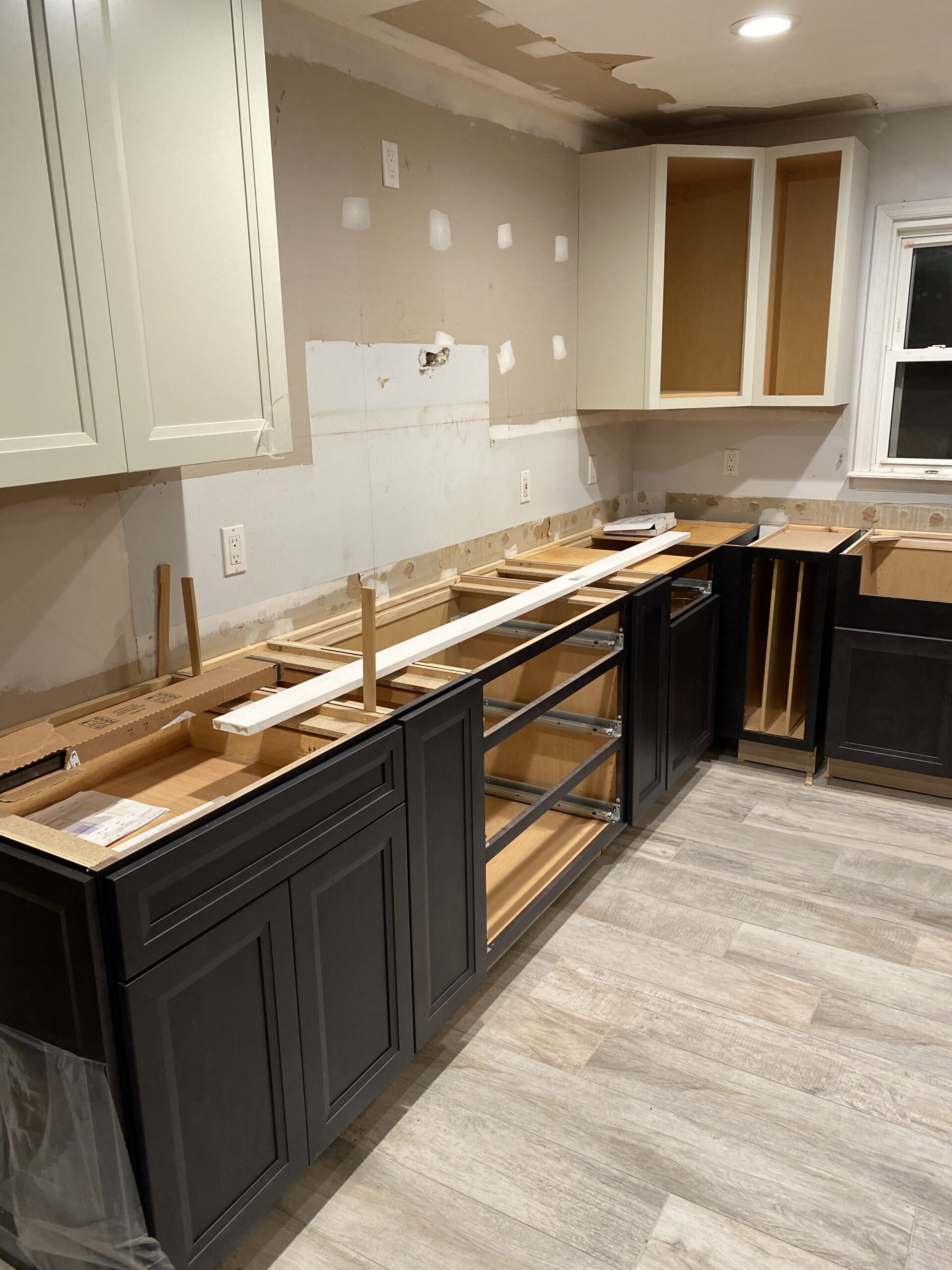 A residential kitchen under construction being renovated with new cabinets and floors.