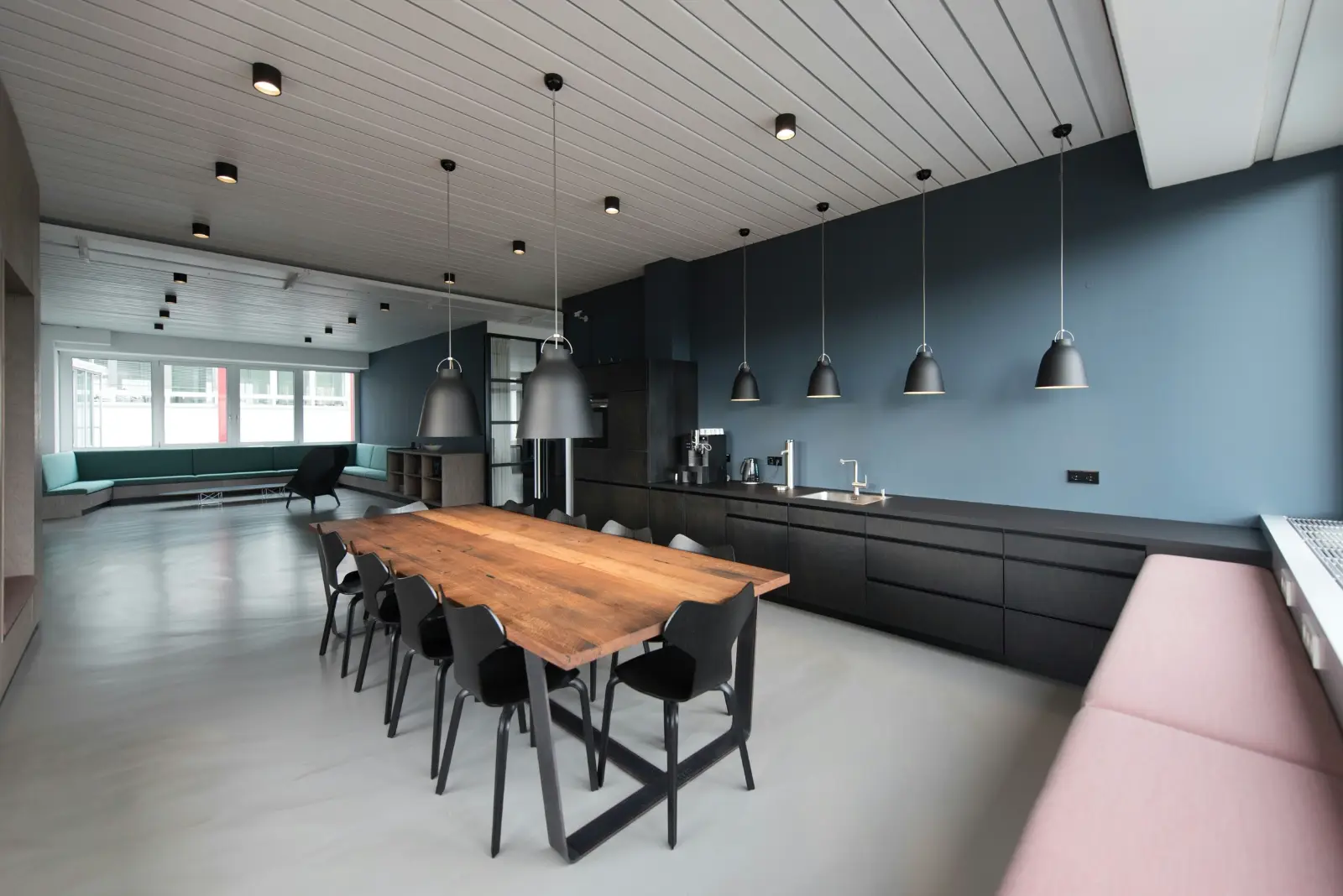 Request a quote Tacoma contractor office: modern break room with a long communal table and pendant lighting